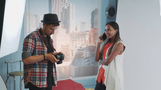 istock Professional photographer asking model to stop talking on smartphone and continue working 1203330904