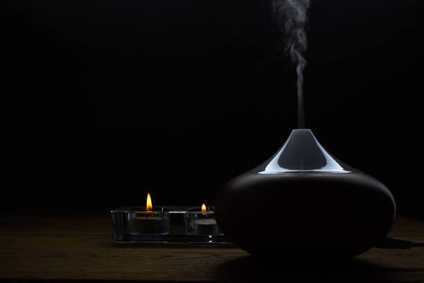 istock Aromatherapy. Essential oil aroma diffuser against dark background with copy space. 1203331339