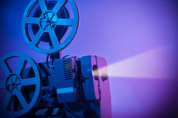 istock Vintage old fashioned projector in a dark room projecting a film 1203331368