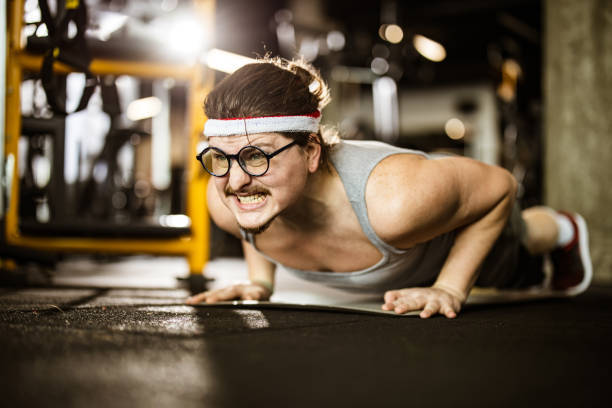 istock Nerdy male athlete making an effort while exercising push-ups in a gym. 1203331482