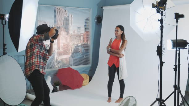 istock Professional photographer asking model to change poses while make a photo shoot in studio 1203332140