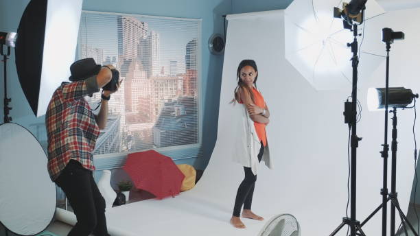 istock Professional photographer asking model to change poses while make a photo shoot in studio 1203332175