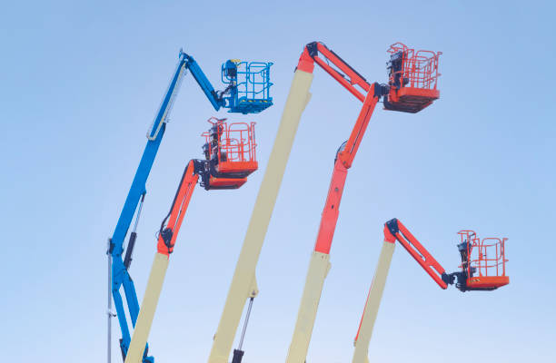 istock Access platform equipment powered high in sky in blue orange and yellow for high working platform height safety at construction building site 1203332202