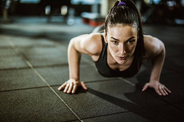 istock Determined athletic woman exercising push-ups in a gym. 1203332261