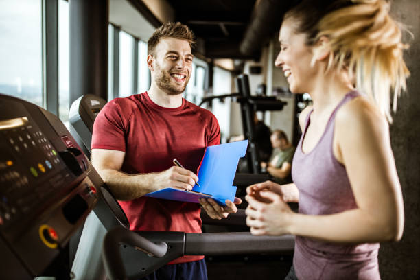 istock Happy coach taking notes while being next to his athlete in a gym. 1203333522