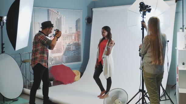 istock Beautiful african model posing for photo shoot while assistant adjusting the lighting 1203333676