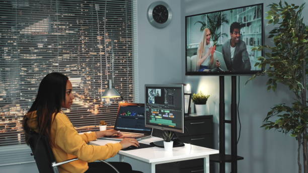 istock African american female video editor works on the computer and mounts video from different frames 1203335388