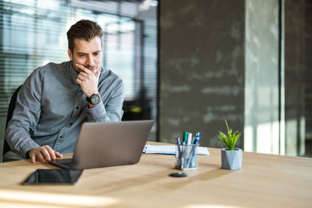 istock Thoughtful businessman reading an e-mail on laptop in the office. 1203336574