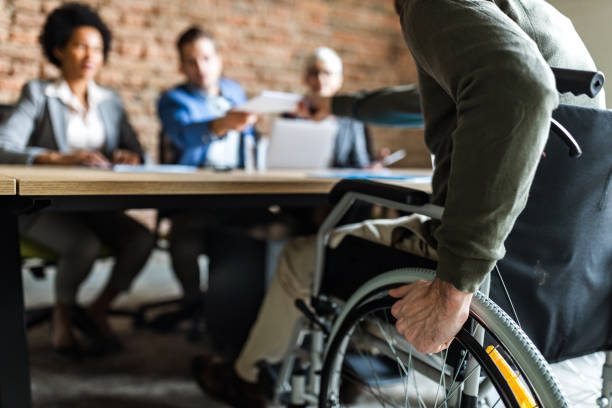 primer plano de un candidato en silla de ruedas en una entrevista de trabajo. - physical impairment wheelchair disabled accessibility fotografías e imágenes de stock