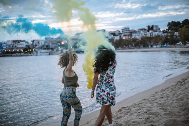istock Friends running on a beach with smoke bombs 1203338101