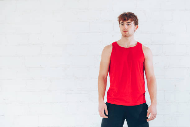 Young man training Young man training with red shirt and black pants on white background sleeveless top stock pictures, royalty-free photos & images