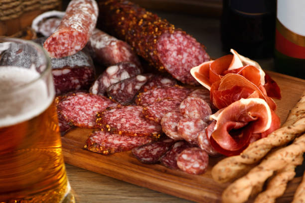 Antipasti dish with bacon, jerky, salami, crispy grissini with cheese. A meat appetizer is a great idea for a beer. stock photo