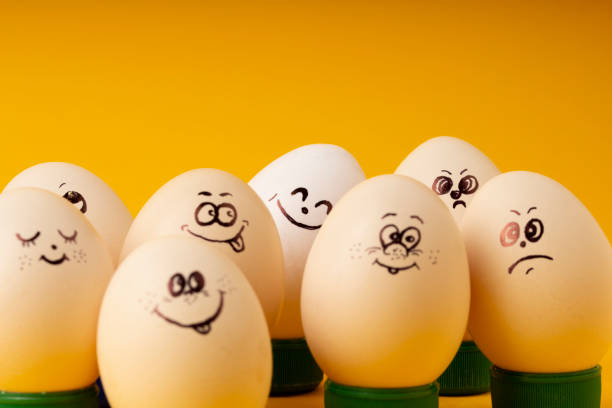 istock Funny smiling smileys eggs on yellow 1203346137