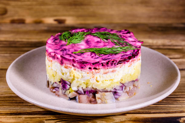 istock Ceramic plate with russian traditional new year salad herring under fur coat (shuba) and on rustic wooden table 1203346699