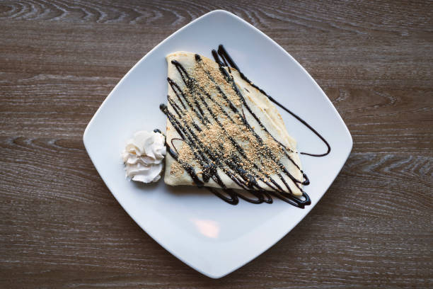 istock Fried pancakes with cream on old wooden table. Top view 1203348325