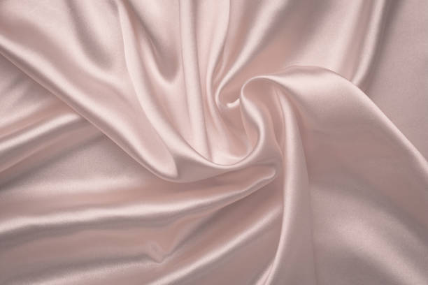 istock Abstract silk background. Soft pink shiny fabric. Delicate rose textile texture. Satin folds, waves pattern. Pastel silky backdrop with curves, luxury fashion. 1203349767