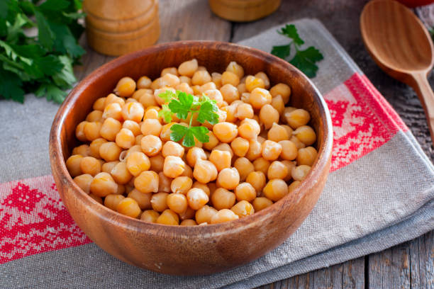 istock Boiled chickpeas in a wooden bowl on a wooden table, selective focus 1203349959