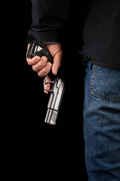 istock Man with a gun on a black background. 1203353211