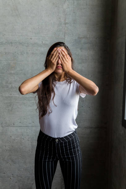 istock Woman with Hands Covering Eyes Indoor 1203353568