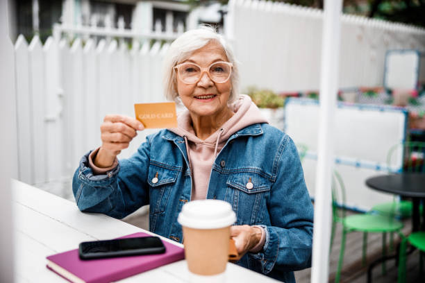 grand-mère gaie avec la carte de crédit dans la photo de stock de café - women telephone senior adult on the phone photos et images de collection