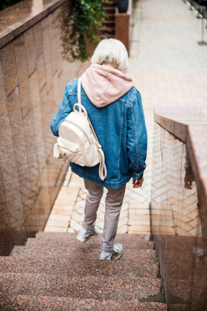 istock Aged woman going downstairs outdoors stock photo 1203355731