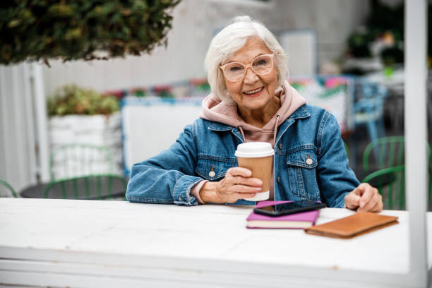 vieille dame gaie sur la photo de stock de terrasse de café - women telephone senior adult on the phone photos et images de collection