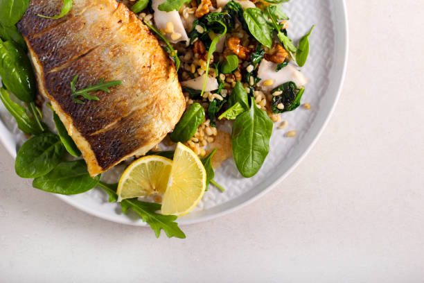 istock Fried sea bass fish and salad 1203356841