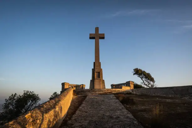 Photo of Sant Salvador big stone Cross in Majorca (Balearic Islands - Spain), Beautiful old stone cross during sunrise early in the morning