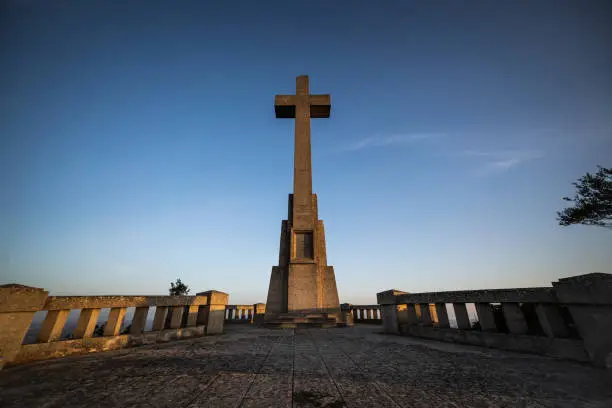 Photo of Sant Salvador big stone Cross in Majorca (Balearic Islands - Spain), Beautiful old stone cross during sunrise early in the morning