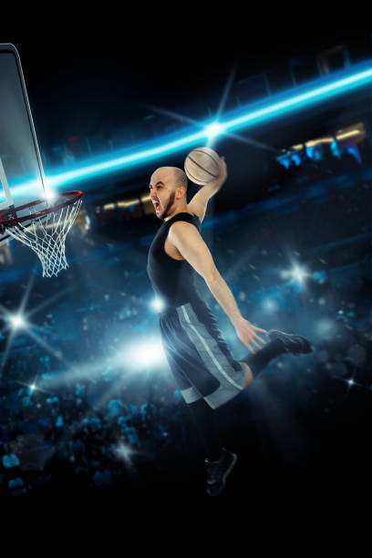 istock Basketball player makes slam dunk on stadium 1203361692