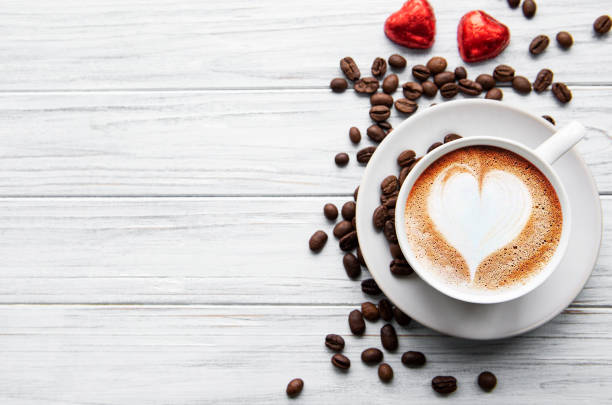 テーブルの上にハートパターンを持つコーヒーのカップ - coffee heart shape coffee cup cup ストックフォトと画像