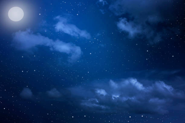 istock Starry night sky with stars and moon in cloudscape background 1203364452