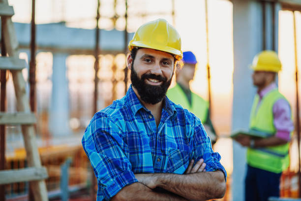 istock Masculine blue collar worker with beard and helmet 1203370662