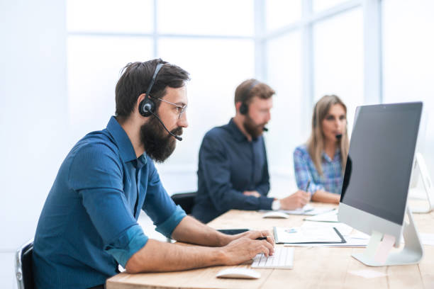 istock close up. business man in a headset working on a computer 1203370726