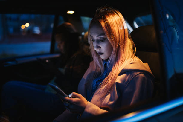 istock Female friends text messaging in the car 1203371826