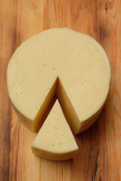 istock A triangular piece of cheese cut off, on a wooden surface. The view from the top 1203372908