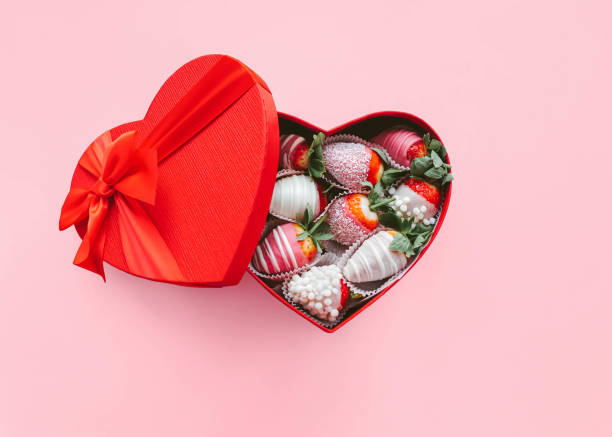 Valentine's Day Romantic gift Strawberry sweets in sugar are lying in heart shape red gift box on pink background chocolate covered strawberries stock pictures, royalty-free photos & images