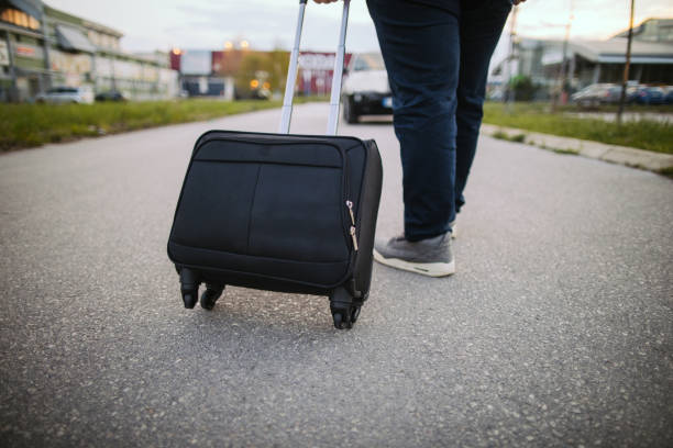 istock Man with suitcase is walking on the street 1203374598
