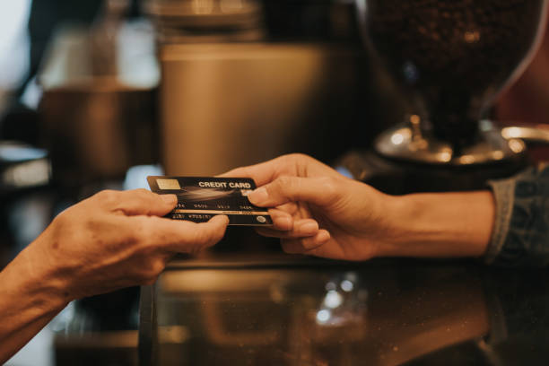 istock Women hand using credit card at the coffee shop 1203375312
