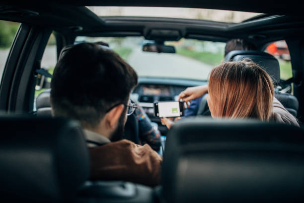 istock Friends are using phone in a car 1203375646
