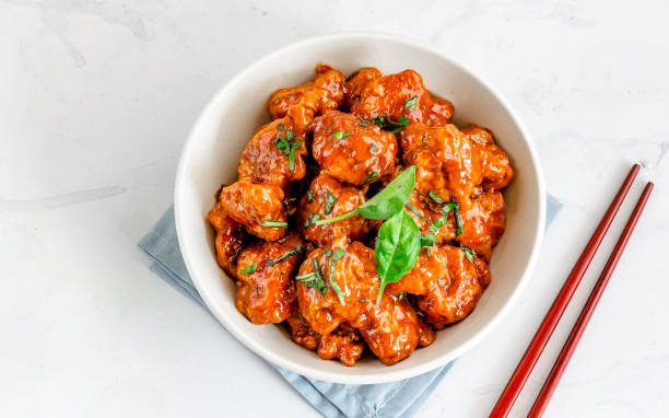istock Thai Basil Chicken, Asian Style Chicken in a White Bowl with Chopsticks, White Background, Top View Photo 1203376683