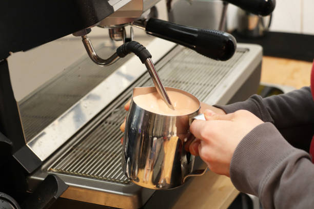 istock Making coffee. Girl is beating milk with a coffee machine 1203378619