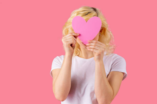 머리, 사랑, 데이트 컨셉을 덮는 핑크 하트를 들고 있는 젊은 여성의 스튜디오 초상화 - february valentines day heart shape love 뉴스 사진 이미지
