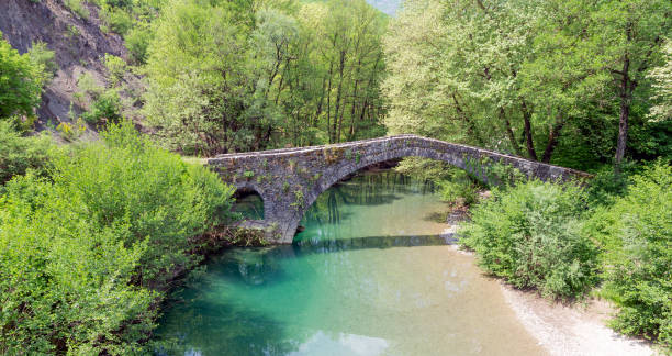 Kamper Aga stone bridge, Epirus, Greece. Kamper Aga is an old one-arch stone bridge, on the contribution of the rivers Vardas and Zagoritikos near the village of Miliotades, in the municipality of East Zagori, in Epirus. The arch is approximately 18 meters-wide and 5 meters high. zagori stock pictures, royalty-free photos & images