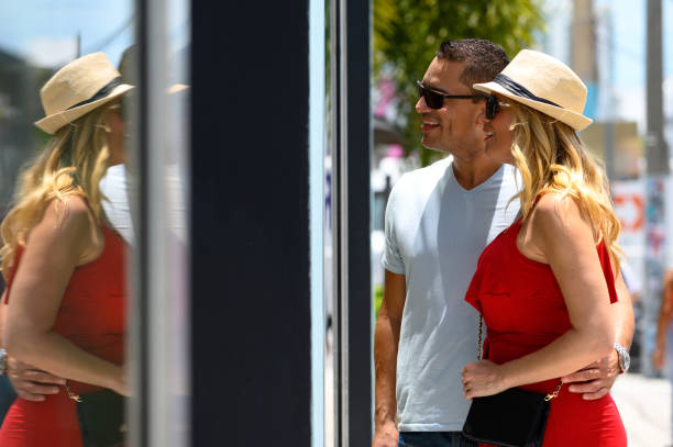 istock Smiling couple looking at store window in city 1203381566