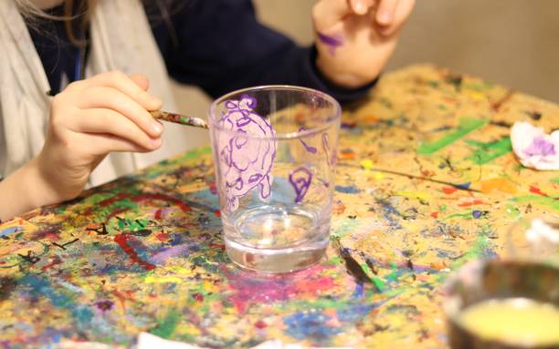 istock girl paints a glass mug with paints 1203382188