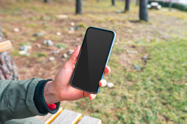 istock Hand Holding Black Blank Screen Phone with Blank Screen Outdoor 1203382438