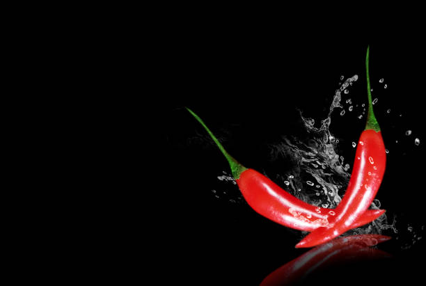 istock red pepper water on black background 1203382762