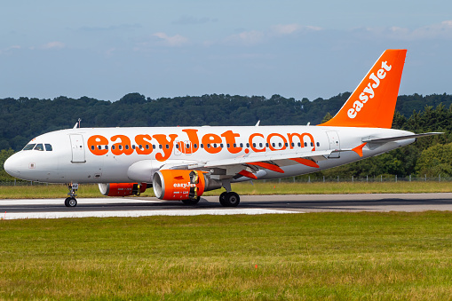 EasyJet Airbus A319-111 G-EZBZ taxiing to the end of runway 27 having just landed. This is one of a few aircraft left still wearing the older livery, before the changed to the 'Bandana' style.
