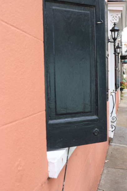 istock Black shutters and peach facade 1203391340